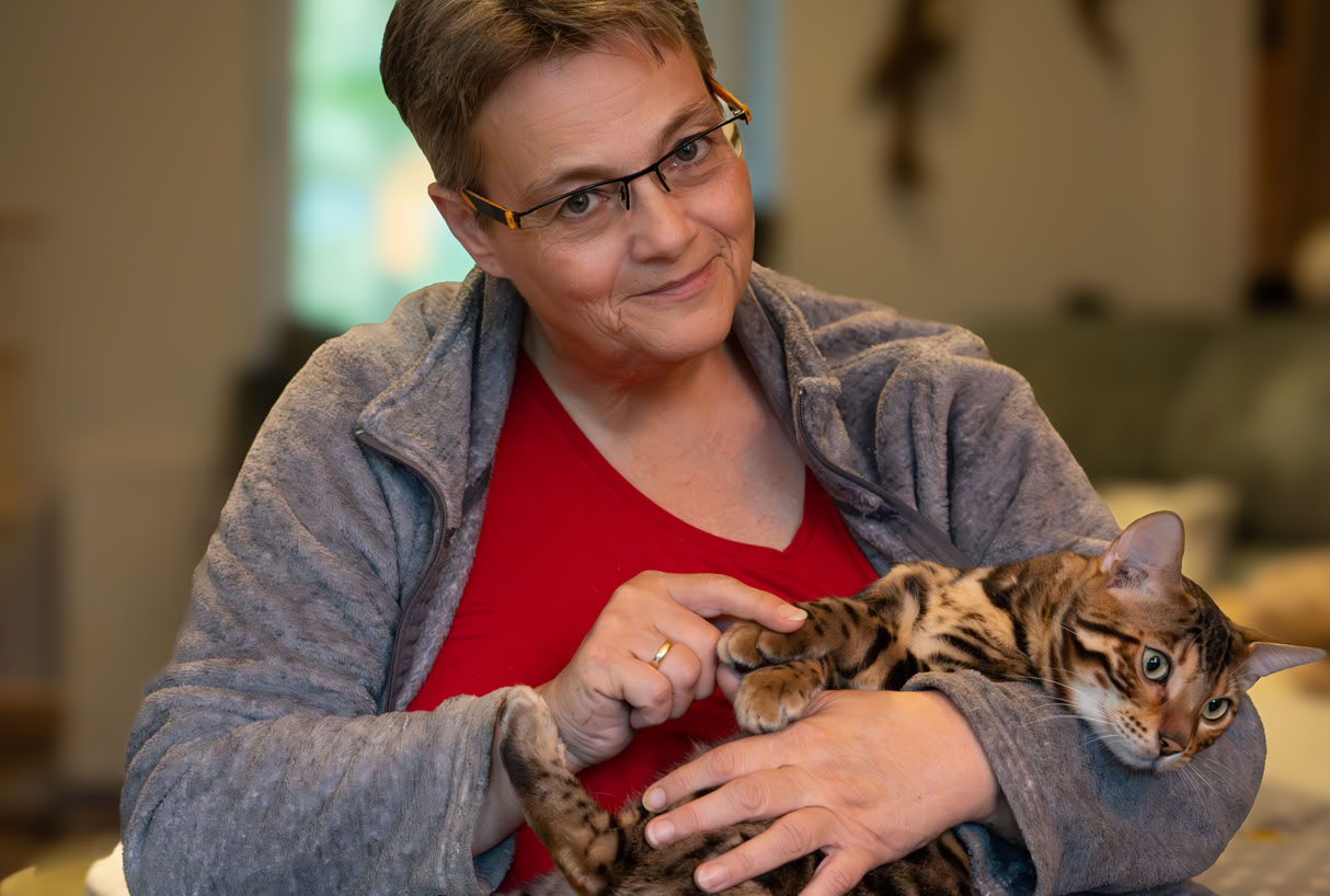 Silke Urff mit einer entspannten Katze auf dem Schoß